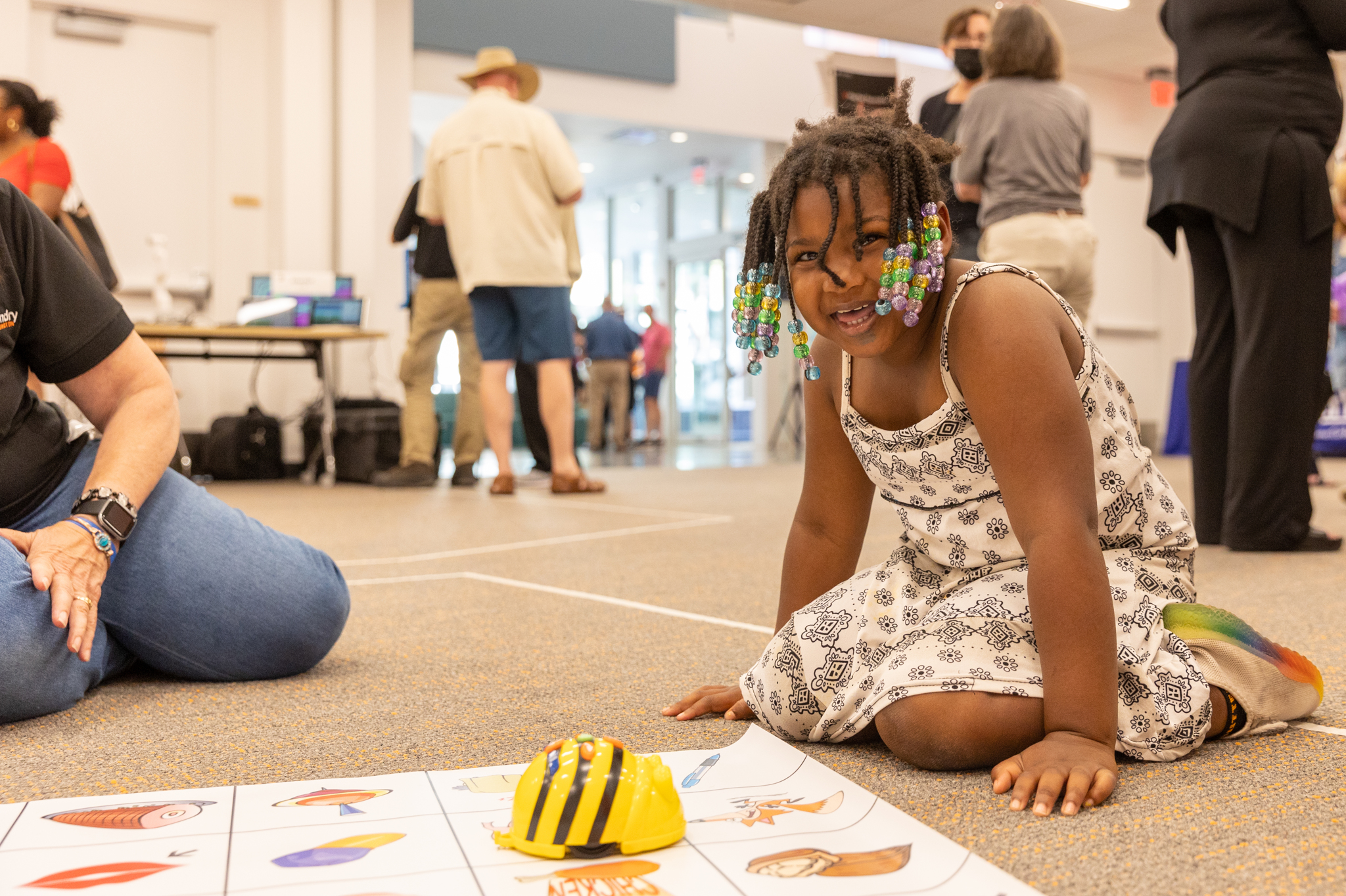 One of our younger attendees at our Open House event, sitting on the floor playing with a robotics toy