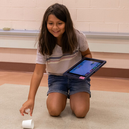STEAM camp attendee working with technology to complete an activity